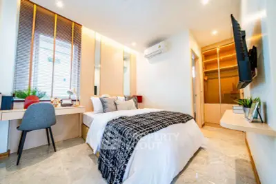 Modern bedroom with stylish decor, built-in wardrobe, and cozy workspace