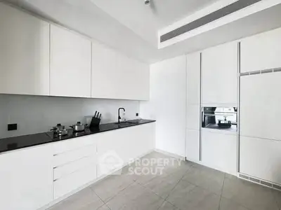 Sleek modern kitchen with white cabinetry and built-in appliances