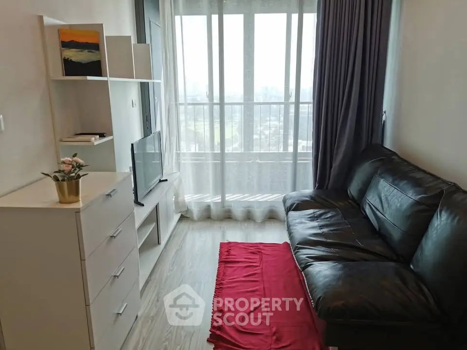 Modern living room with leather sofa and large window offering city view