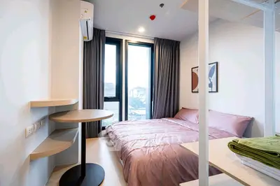 Modern bedroom with large window and stylish decor, perfect for urban living.