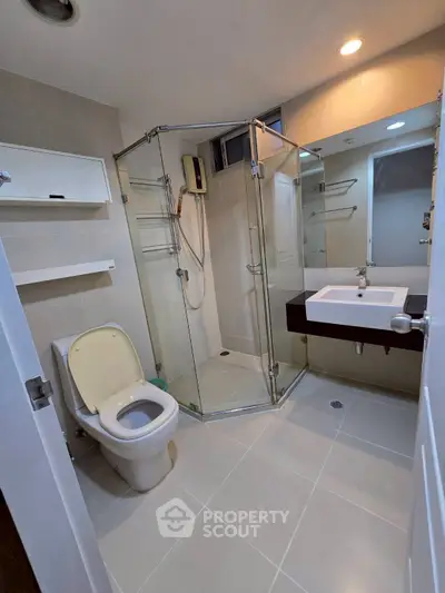 Modern bathroom with glass shower and sleek fixtures in a contemporary apartment.