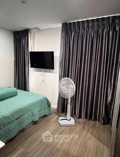 Cozy bedroom with modern decor, featuring a wall-mounted TV and elegant curtains.
