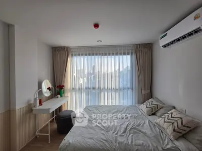 Bright and cozy bedroom with large window and modern decor in a stylish apartment.