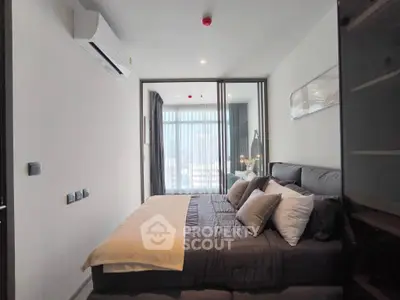 Modern bedroom with large window and stylish decor, featuring a cozy bed and elegant lighting.