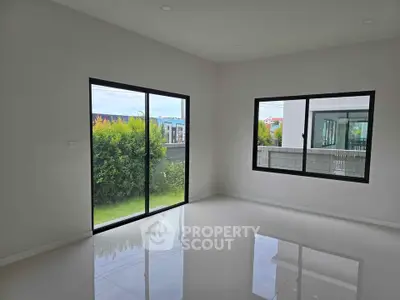 Spacious empty room with large windows and garden view, perfect for customization.
