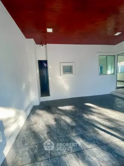 Spacious modern patio with elegant tile flooring and sleek white walls, perfect for outdoor relaxation.