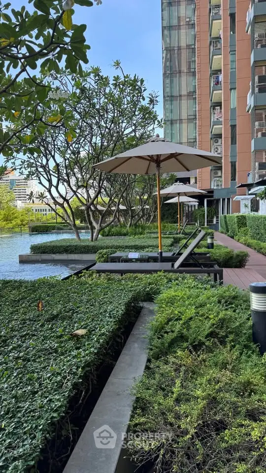 Luxurious poolside area with sun loungers and umbrellas in a modern residential complex.