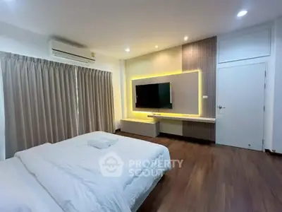 Spacious modern bedroom with elegant lighting and wooden flooring