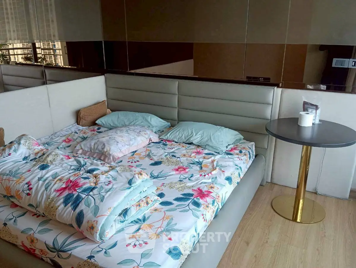 Luxurious bedroom with modern decor and floral bedding in a stylish apartment.