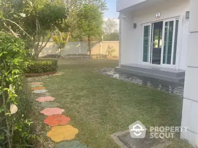 Charming garden view with colorful stepping stones leading to a modern patio door.