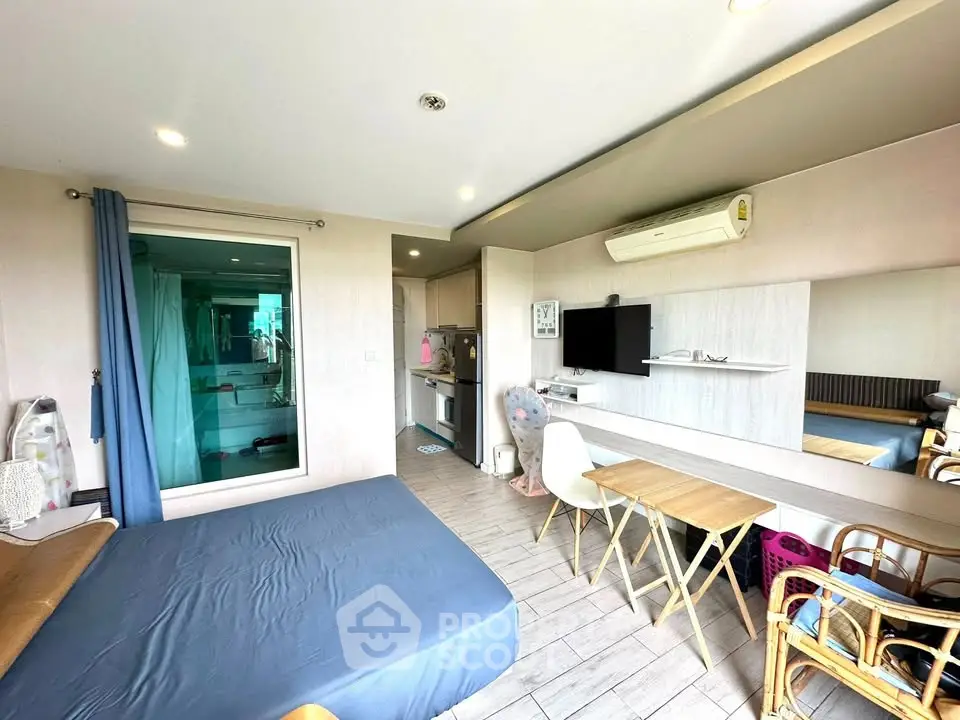 Modern studio apartment with open layout, featuring a cozy bed, compact kitchen, and stylish decor.