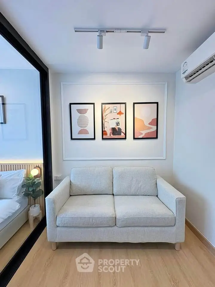 Modern living room with cozy sofa and stylish wall art in a bright apartment.