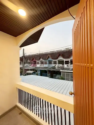 Charming balcony view of colorful townhouses in a serene neighborhood setting.