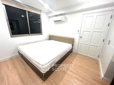 Spacious bedroom with modern design and large window for natural light.