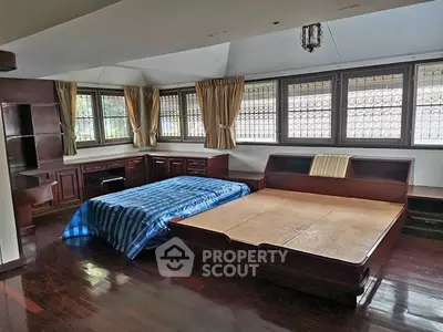 Spacious bedroom with large windows and wooden flooring