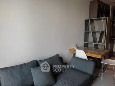 Modern living room with stylish sofa and compact study area, perfect for urban living.