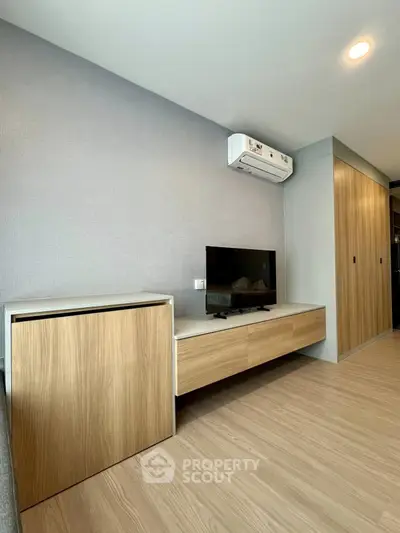 Modern living room with sleek wooden furniture and mounted TV