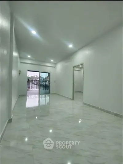 Spacious modern living room with glossy marble flooring and ample natural light.