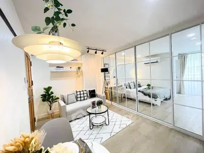 Modern open-concept living room with stylish decor and mirrored wardrobe