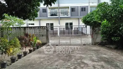 Spacious residential driveway with gated entrance and lush greenery