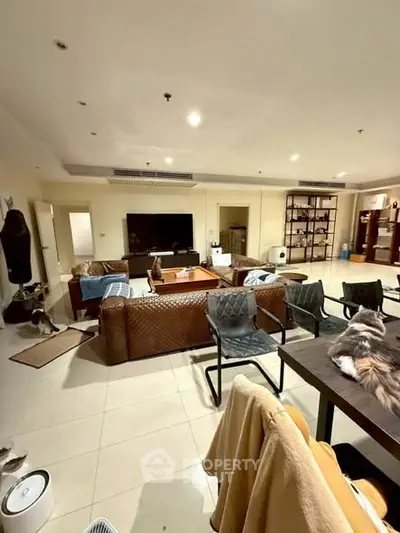 Spacious living room with modern furniture and large TV, perfect for family gatherings.