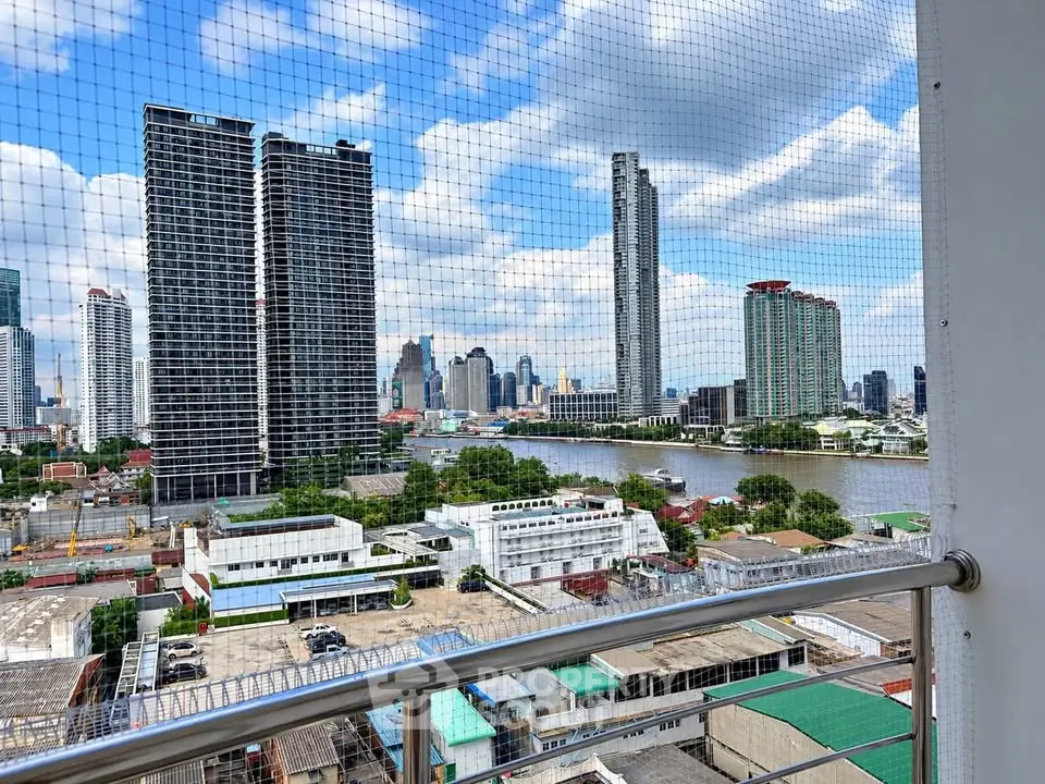 Stunning cityscape view from a high-rise balcony overlooking a river and modern skyscrapers.