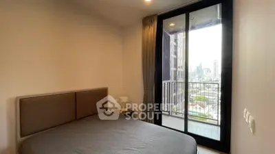 Cozy bedroom with city view and private balcony access in modern apartment.