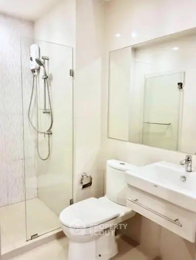 Modern bathroom with glass shower and sleek fixtures in a contemporary apartment.