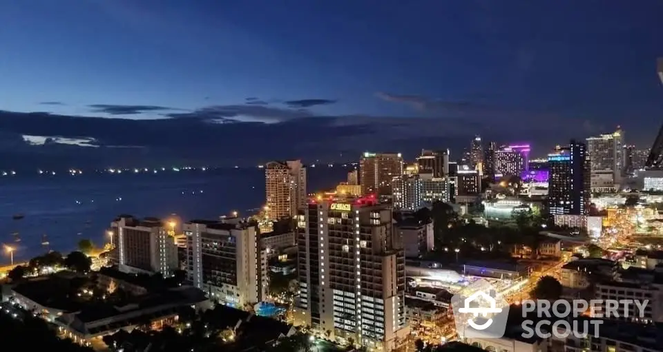 Stunning cityscape view of vibrant skyline at night with ocean backdrop