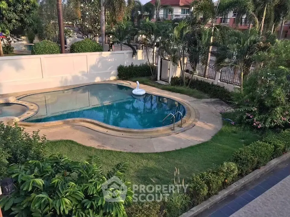 Luxurious private pool surrounded by lush greenery in a serene residential area.