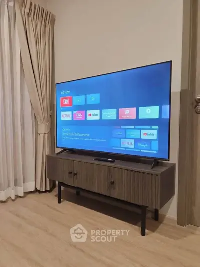 Modern living room with sleek TV setup and elegant curtains, perfect for entertainment.