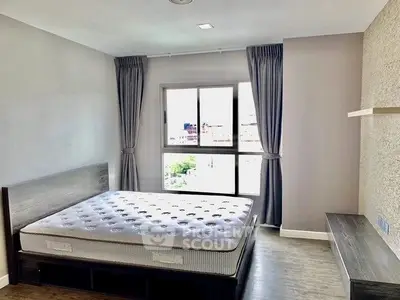 Spacious bedroom with large window and modern decor