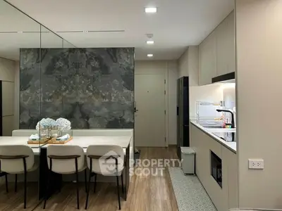 Modern kitchen with sleek design and dining area, featuring elegant decor and ample lighting.