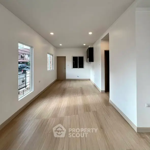 Spacious and bright living room with modern flooring and ample natural light.