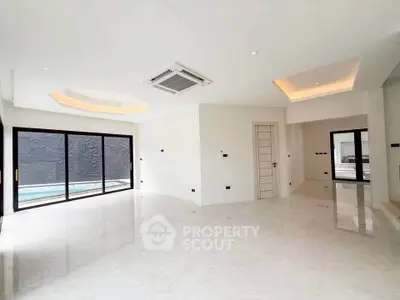 Spacious modern living room with pool view and elegant ceiling design