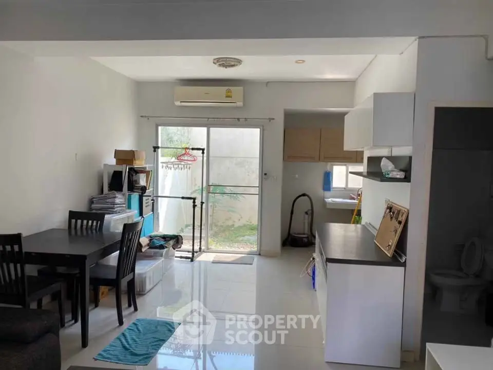 Spacious open-layout living area with dining set and modern kitchen, ideal for family gatherings.