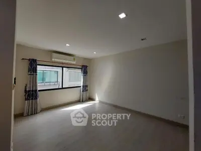 Spacious unfurnished room with large window and air conditioning