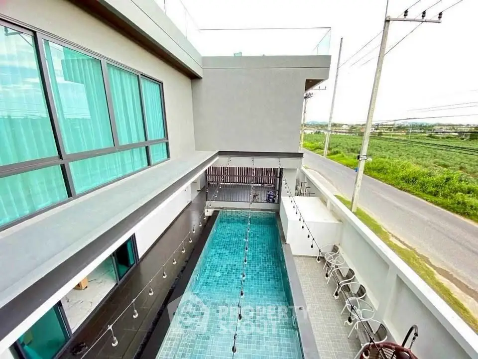 Modern residential building with sleek pool and expansive countryside view.