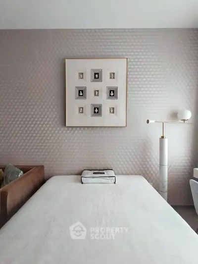 Elegant bedroom with modern decor and stylish wall art, featuring a cozy bed and contemporary lighting.