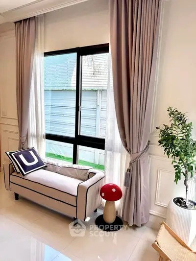 Elegant living room with stylish sofa, large window, and chic decor
