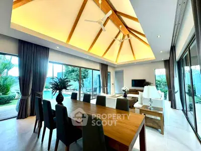 Luxurious open-plan living room with high ceilings and garden view, perfect for entertaining.