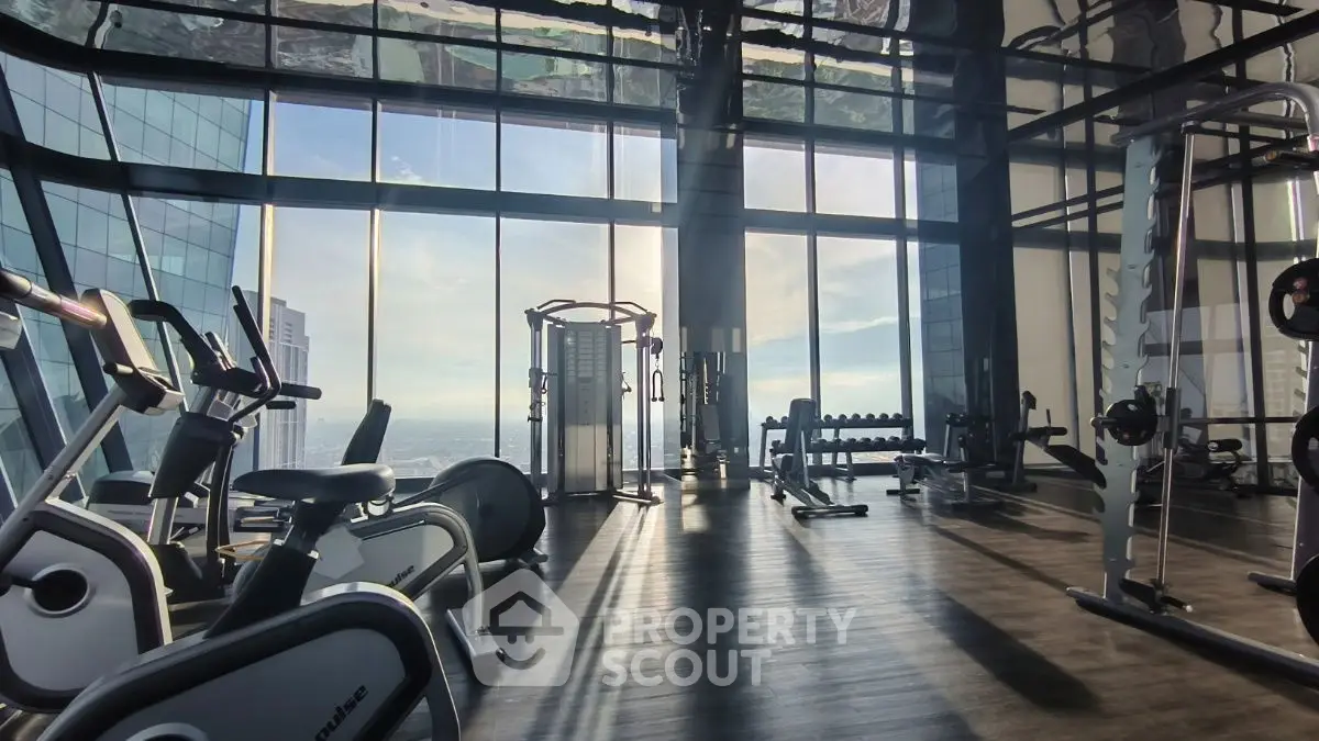Luxurious high-rise gym with panoramic city views and modern fitness equipment.
