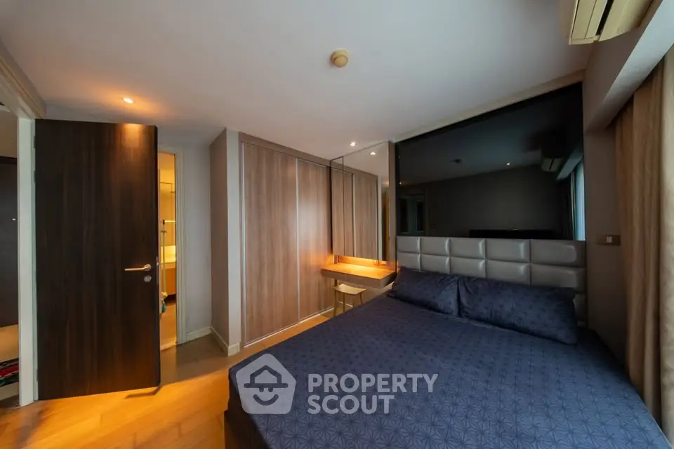 Modern bedroom with stylish wooden wardrobe and cozy bed in a contemporary apartment.