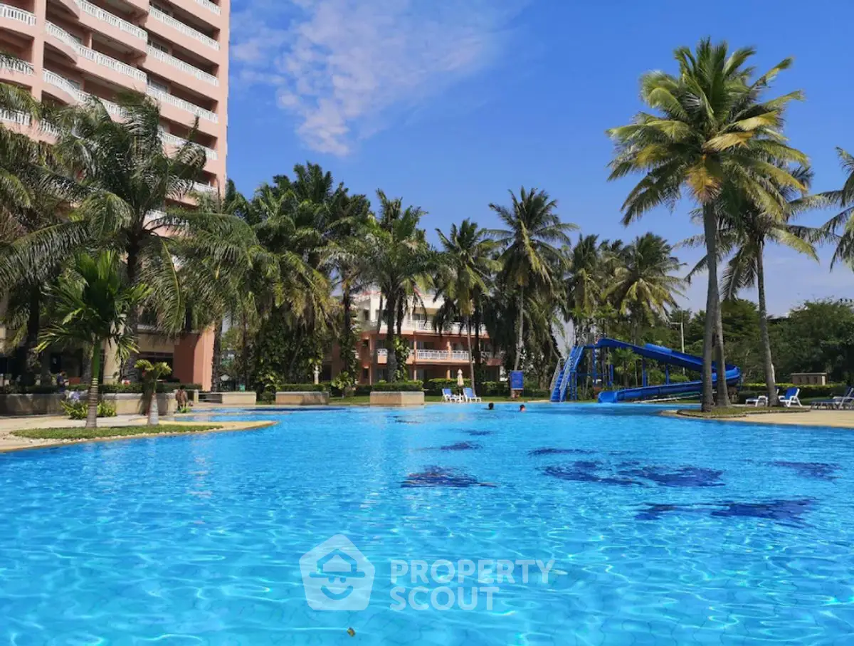 Luxurious resort-style pool with palm trees and modern building