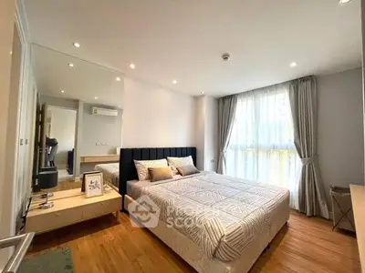 Spacious bedroom with large windows, modern furnishings, and an en-suite bathroom, offering a comfortable and stylish living space.