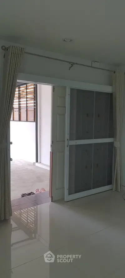Spacious interior with sliding door leading to a bright balcony area.
