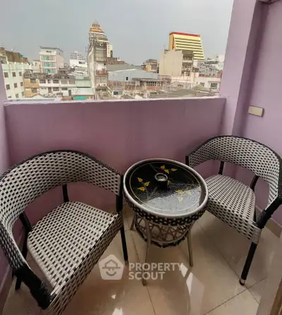 Charming balcony with city view and cozy seating area.