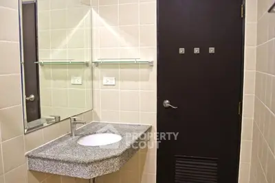Modern bathroom with granite countertop and large mirror