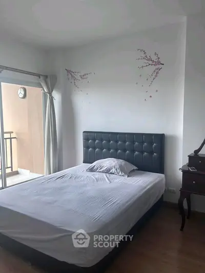 Cozy bedroom with modern decor and balcony access, perfect for relaxation.