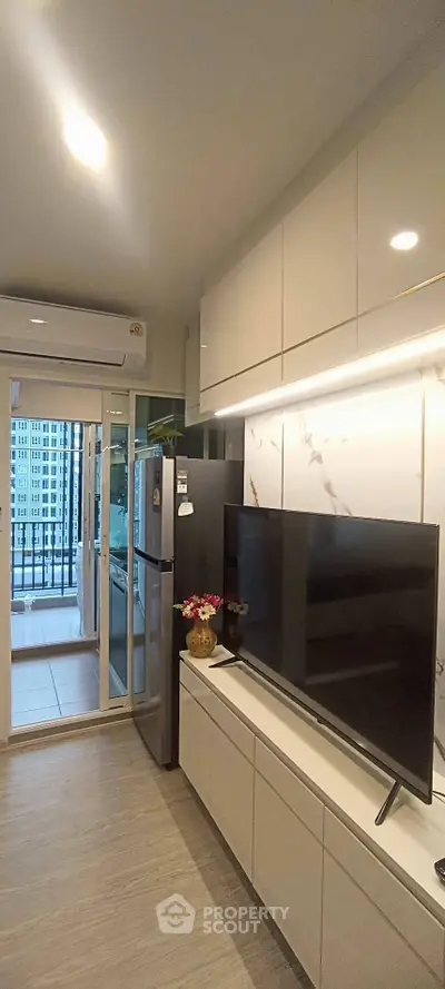 Modern living room with sleek TV setup and balcony view